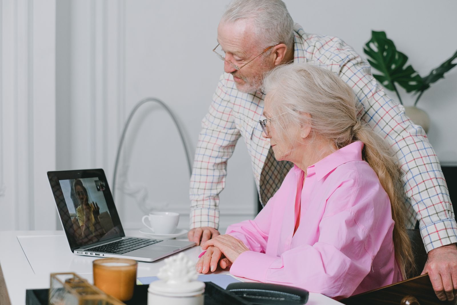 An older couple connecting with family on a laptop.